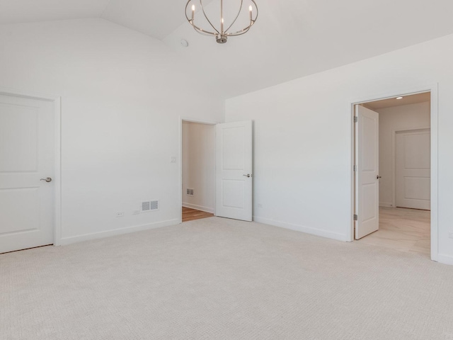 unfurnished bedroom featuring lofted ceiling, light carpet, visible vents, and baseboards