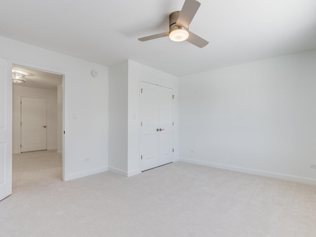 unfurnished bedroom with baseboards, a closet, and light colored carpet