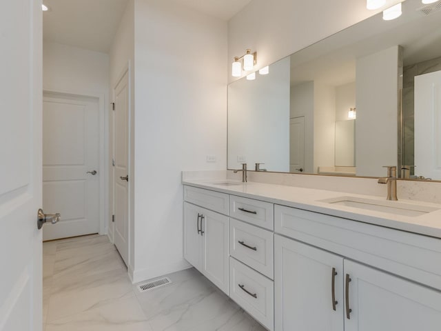 full bathroom featuring marble finish floor, double vanity, a sink, and visible vents