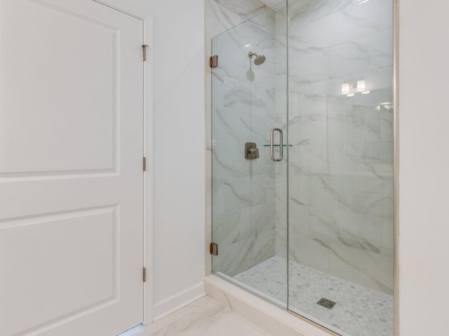 full bath with marble finish floor, baseboards, and a marble finish shower