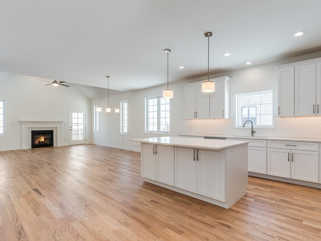 kitchen with open floor plan, light countertops, and white cabinets