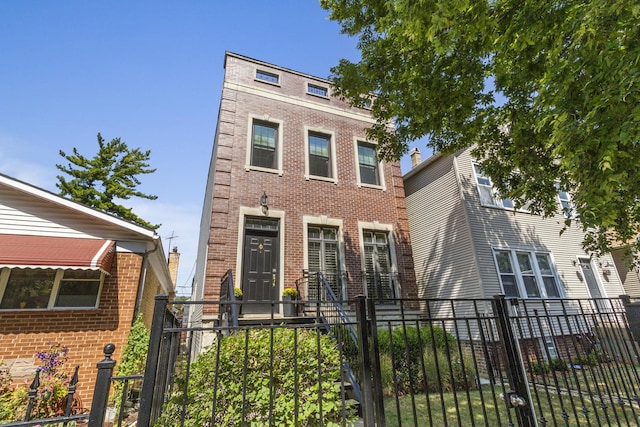 view of front facade featuring brick siding and a fenced front yard