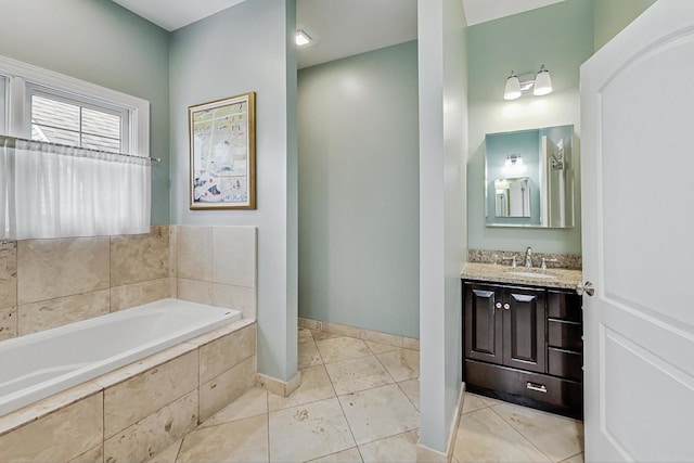 bathroom with a garden tub, vanity, baseboards, and tile patterned floors