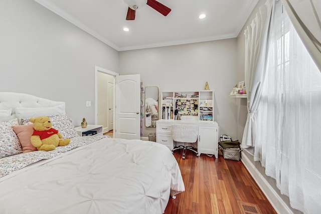 bedroom featuring crown molding, visible vents, ceiling fan, and wood finished floors