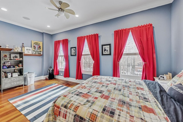 bedroom featuring multiple windows, baseboards, and wood finished floors