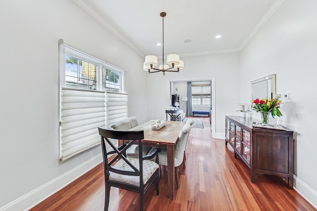 dining room with crown molding, wood finished floors, and baseboards