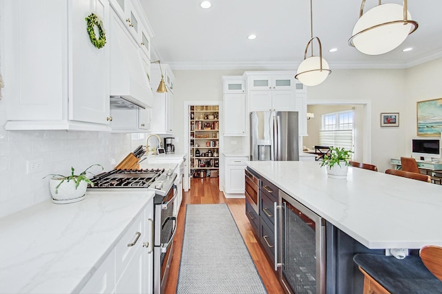 kitchen featuring wine cooler, appliances with stainless steel finishes, white cabinets, a sink, and under cabinet range hood