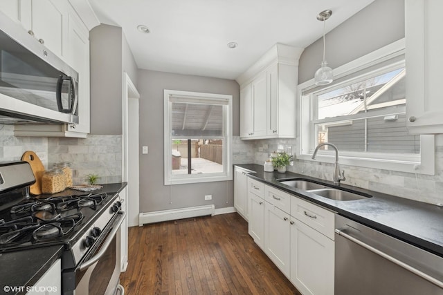 kitchen with stainless steel appliances, white cabinetry, a baseboard heating unit, and sink