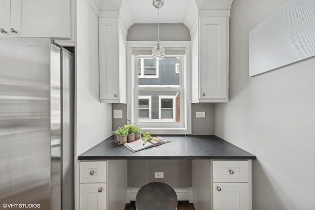 kitchen with decorative light fixtures, stainless steel fridge, and white cabinets