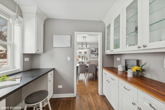 kitchen featuring hanging light fixtures, white cabinetry, plenty of natural light, and dark wood-type flooring