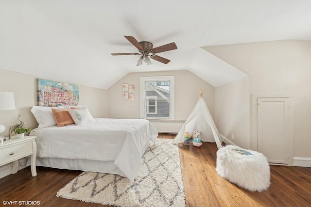 bedroom with dark hardwood / wood-style flooring, radiator, vaulted ceiling, and ceiling fan