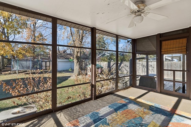 unfurnished sunroom featuring ceiling fan