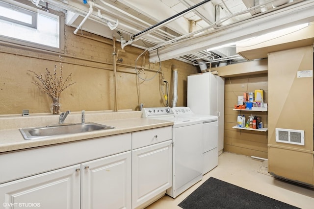 washroom with sink, cabinets, and independent washer and dryer