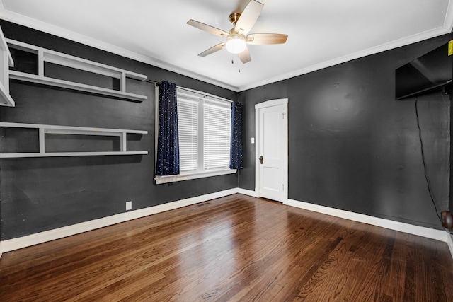 unfurnished room with dark wood-style floors, ornamental molding, baseboards, and a ceiling fan