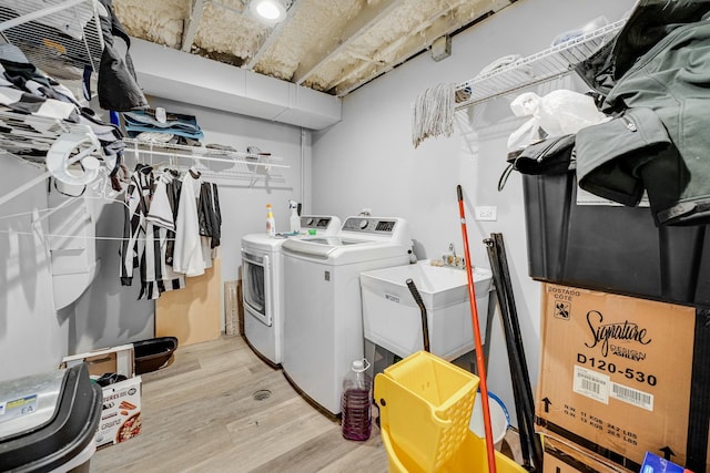 washroom featuring laundry area, a sink, independent washer and dryer, and light wood finished floors