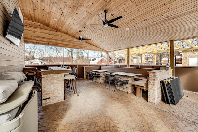 sunroom with lofted ceiling, wooden ceiling, and a ceiling fan