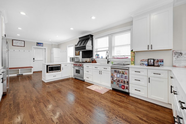 kitchen featuring stainless steel appliances, light countertops, white cabinetry, premium range hood, and a peninsula