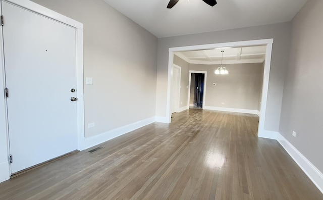 interior space featuring ceiling fan, wood-type flooring, coffered ceiling, and beam ceiling