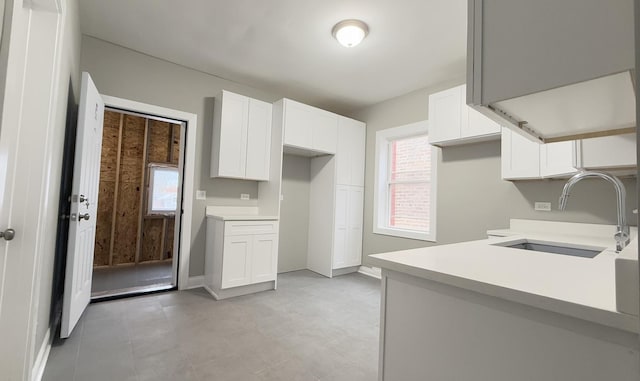 kitchen featuring white cabinetry and sink