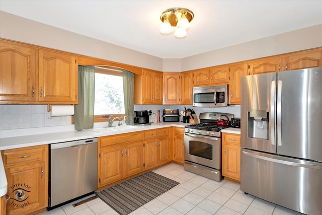 kitchen with light tile patterned floors, appliances with stainless steel finishes, sink, and backsplash