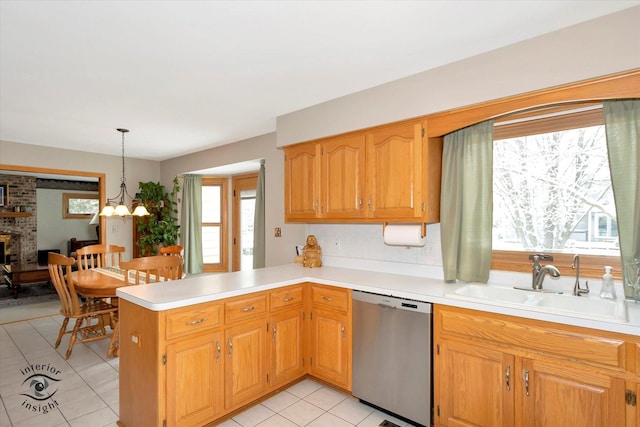 kitchen with pendant lighting, sink, stainless steel dishwasher, kitchen peninsula, and a chandelier