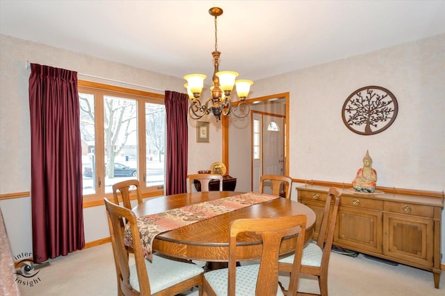 dining space with light colored carpet and a notable chandelier