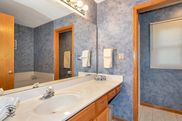 bathroom with tile patterned flooring, vanity, and a bath