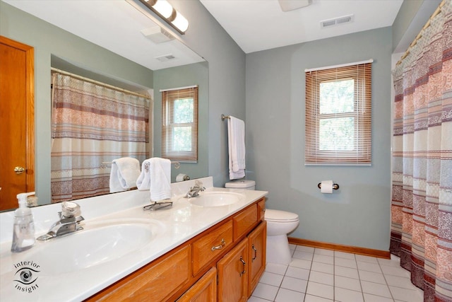 bathroom with tile patterned flooring, vanity, plenty of natural light, and toilet