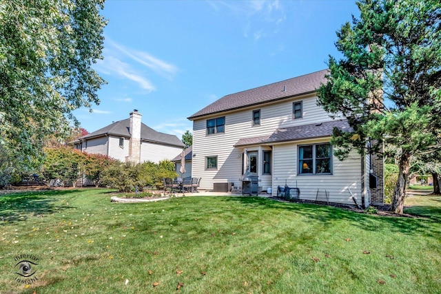 rear view of property featuring a lawn and a patio