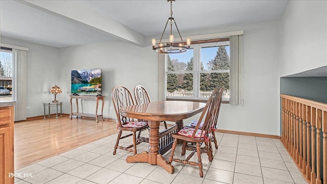 dining room featuring beamed ceiling, a notable chandelier, baseboards, and light tile patterned floors