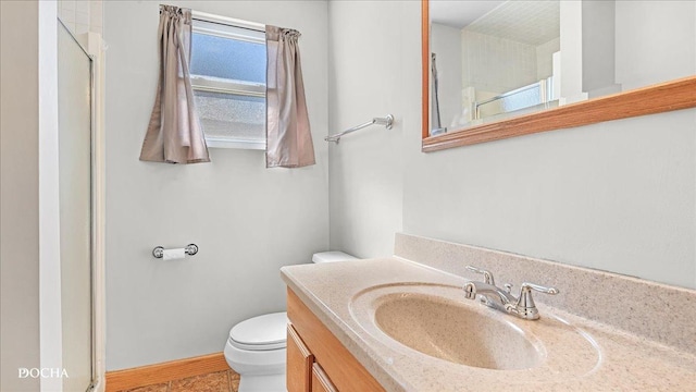 full bathroom with vanity, toilet, a shower, and baseboards