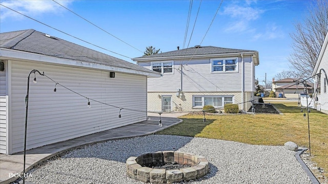 rear view of property with a lawn and an outdoor fire pit