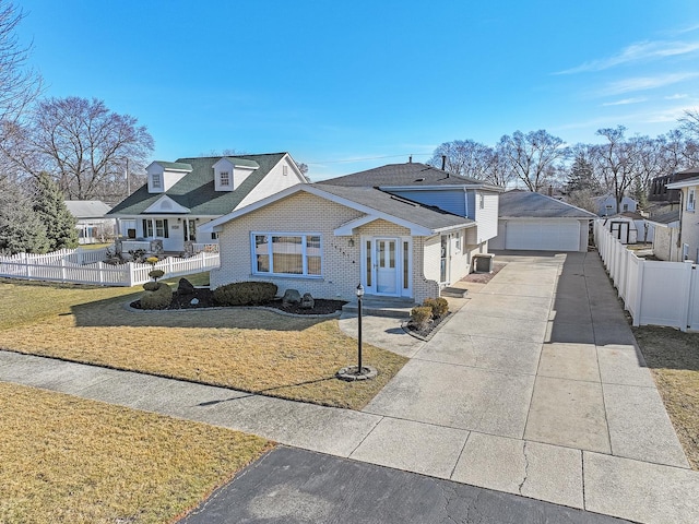 view of front of home with a front lawn, fence, brick siding, and an outbuilding