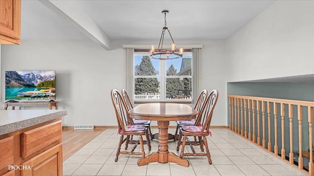 dining space with light tile patterned floors, visible vents, baseboards, and an inviting chandelier