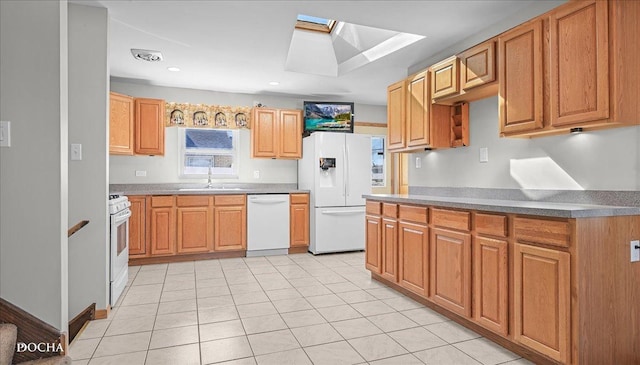 kitchen with white appliances, a skylight, light tile patterned flooring, recessed lighting, and a sink