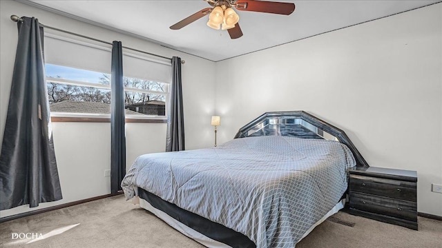 carpeted bedroom featuring baseboards and ceiling fan