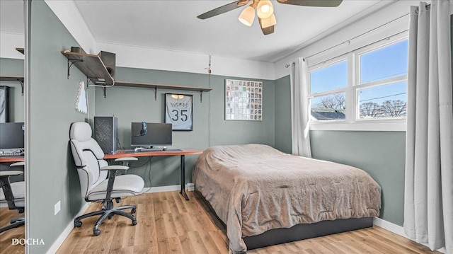 bedroom with a ceiling fan, wood finished floors, and baseboards