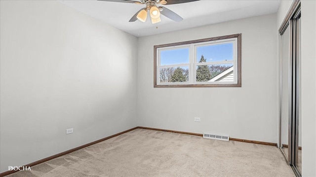 unfurnished bedroom featuring baseboards, visible vents, a closet, and light carpet