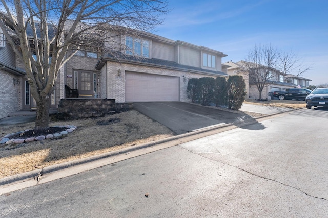 view of front of property with brick siding, driveway, and an attached garage