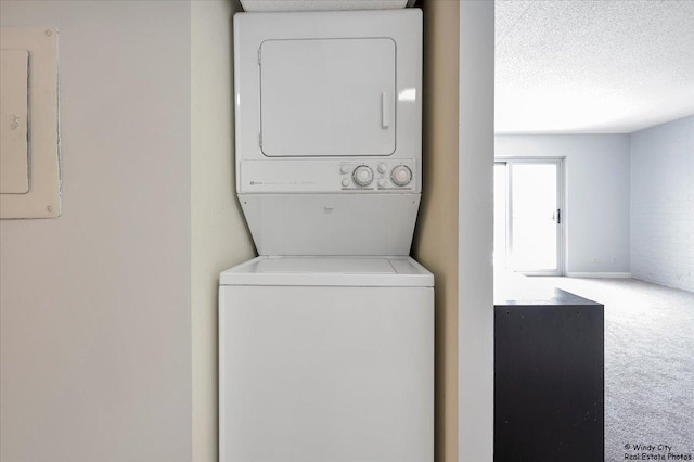 laundry area with stacked washer and dryer, carpet flooring, and a textured ceiling