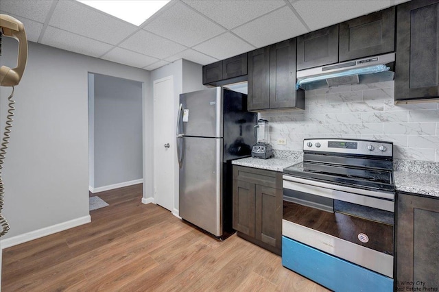 kitchen with backsplash, stainless steel appliances, light stone counters, dark brown cabinetry, and light wood-type flooring