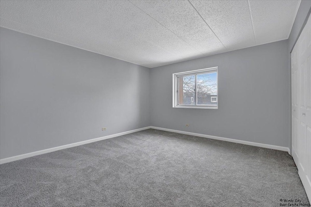 carpeted empty room with a textured ceiling