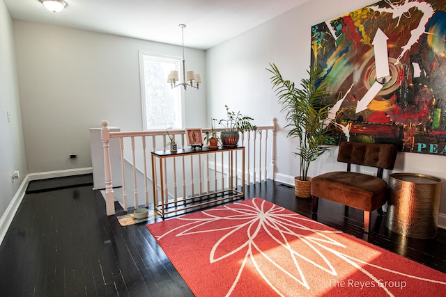 hall with an upstairs landing, a chandelier, baseboards, and hardwood / wood-style floors