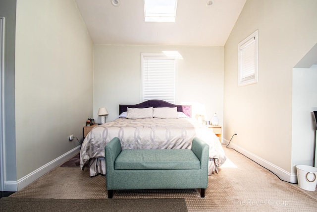 bedroom with vaulted ceiling with skylight, carpet, and baseboards