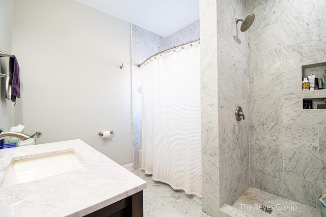 full bathroom featuring a tile shower and vanity