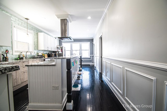 kitchen featuring a sink, wainscoting, a center island, and ornamental molding