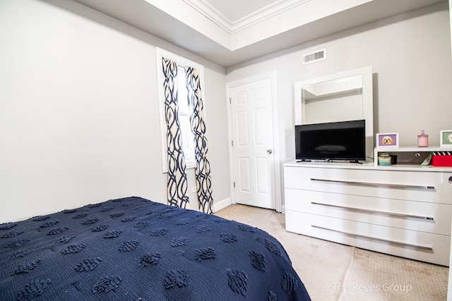 bedroom with visible vents, baseboards, light colored carpet, ornamental molding, and a raised ceiling