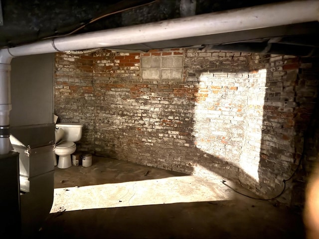 interior space featuring concrete flooring and brick wall