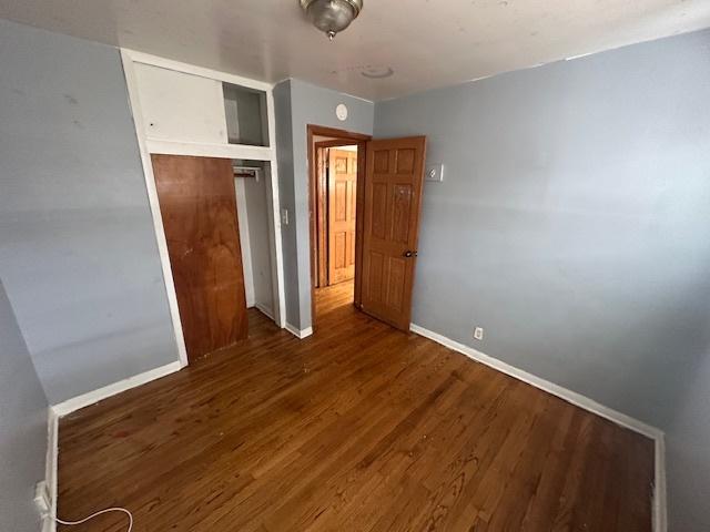 unfurnished bedroom with a closet and dark hardwood / wood-style floors