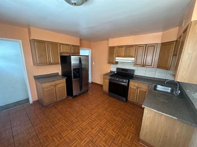 kitchen featuring tasteful backsplash, sink, stainless steel fridge, dark parquet flooring, and range